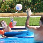 Residential Swimming Pool Safety & Homeowner Liability- man playing with toddler in a pool